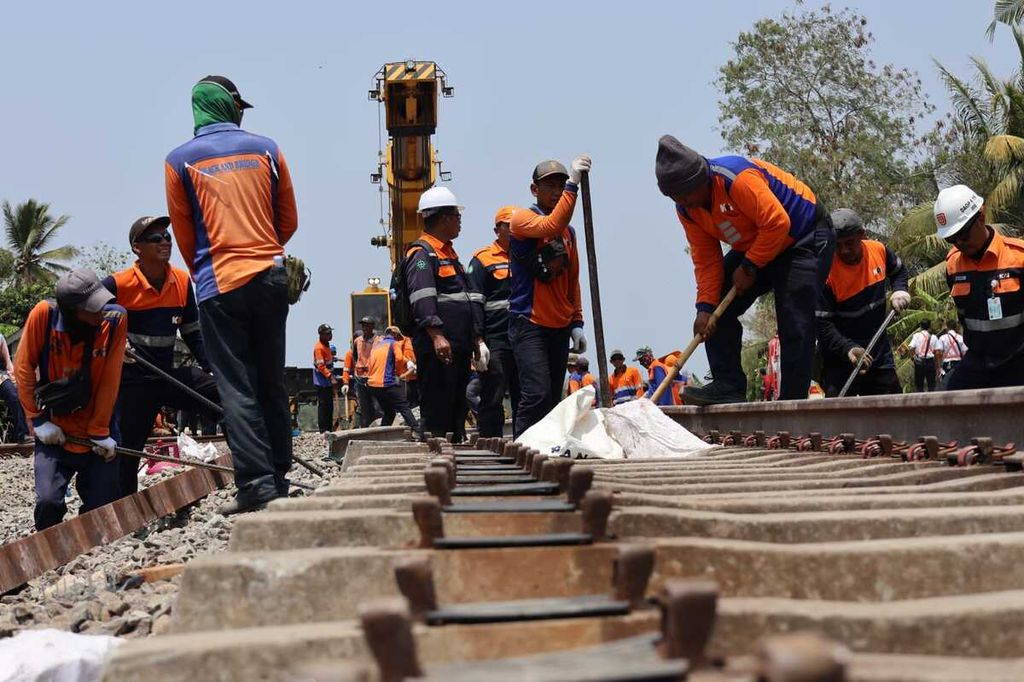 Para pekerja memperbaiki bantalan rel dari beton serta memasang kembali pelat landas yang terlepas di petak lintas Km 520+4 antara Stasiun Sentolo dan Wates, Kulon Progo, Yogyakarta, Rabu (18/10/2023). 