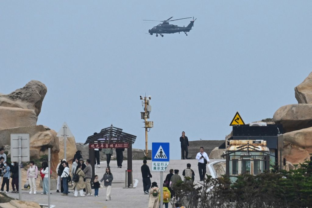  Helikopter Tentara Pembebasan Rakyat China terbang di atas para wisatawan yang melancong ke Pulau Pingtan di Provinsi Fujian pada 7 April 2023. Pulau ini merupakan titik terdekat China ke Taiwan.