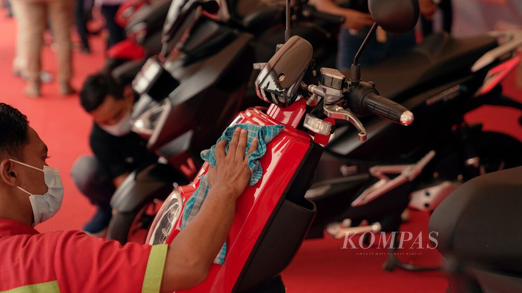 Pekerja mengelap motor listrik Selis yang dipamerkan dalam sosialisasi penggunaan kendaraan listrik di Stasiun Bekasi Timur, Jawa Barat, Minggu (18/4/2021). 