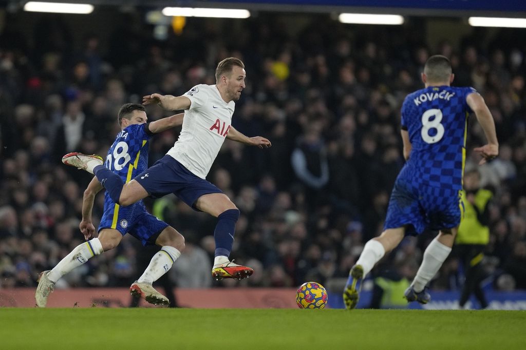 Striker Tottenham Hotspur, Harry Kane (tengah), dijegal oleh kapten Chelsea, Cesar Azpilicueta (kiri), pada laga Liga Inggris di Stadion Stamford Bridge, London, Senin (24/1/2022) dini hari WIB. Pada laga itu, Chelsea menang 2-0.