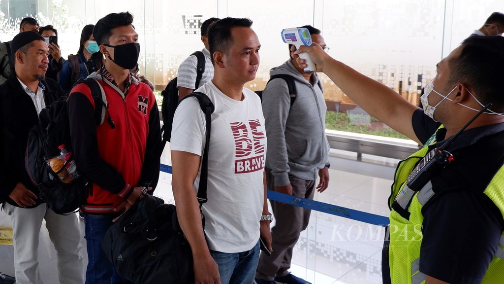 Petugas mengecek suhu tubuh penumpang dengan termometer inframerah di area kedatangan penerbangan domestik Bandara Internasional Jenderal Ahmad Yani, Kota Semarang, Jawa Tengah, Rabu (11/3/2020). Kata "inframerah" ini merupakan kata tunggal.