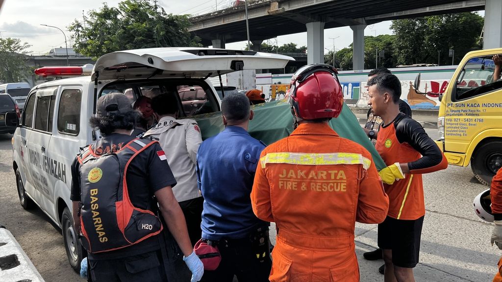 Korban tewas di dalam <i>manhole </i>kabel optik saat dimasukkan dalam ambulans di Pademangan Timur, Jakarta Utara, Rabu (14/12/2022).