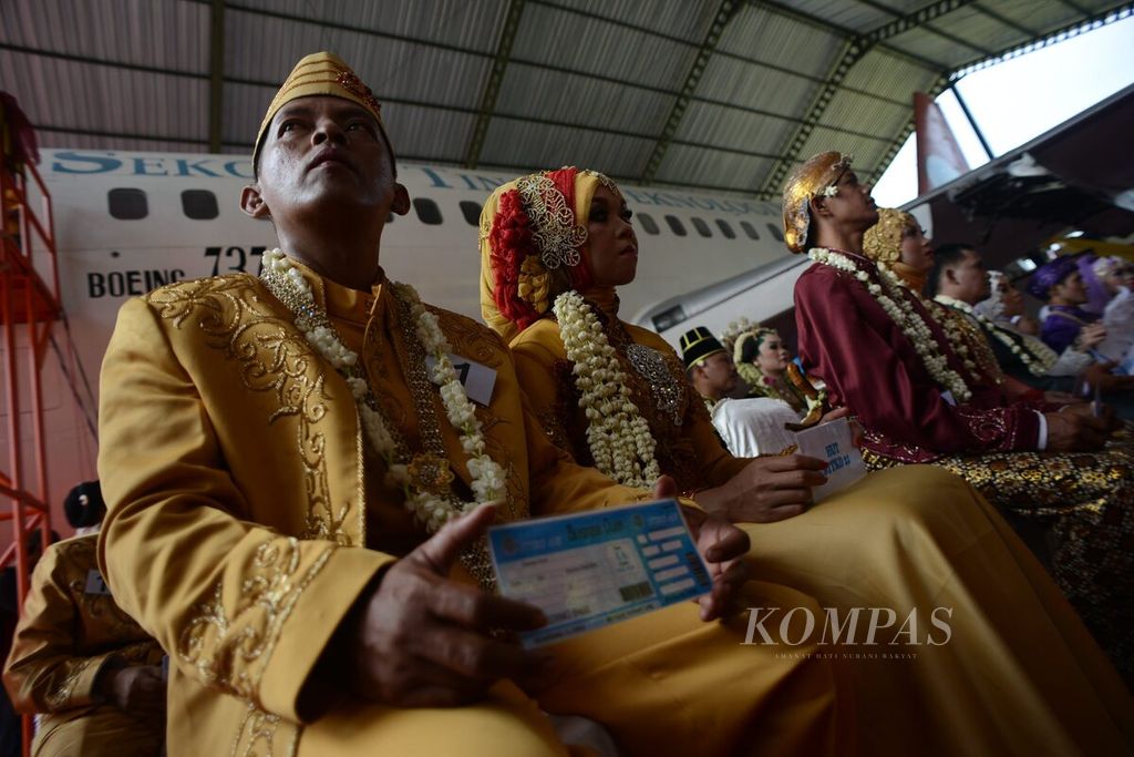 Pasangan calon pengantin bersiap mengikuti acara Nikah Bareng Angkasa di dalam kabin pesawat Boeing 737-200 di Sekolah Tinggi Teknologi Kedirgantaraan Yogyakarta, Kecamatan Sewon, Bantul, Daerah Istimewa Yogyakarta.