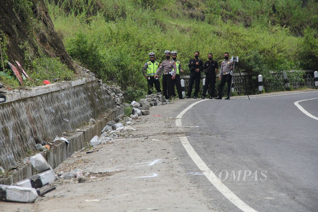 Petugas kepolisian melakukan olah tempat kejadian perkara kecelakaan bus pariwisata di Jalan Imogiri-Dlingo, Kabupaten Bantul, Daerah Istimewa Yogyakarta, Senin (7/2/2022). Kecelakaan bus yang terjadi pada Minggu (6/2/2022) siang pukul 14.00 itu menewaskan 13 orang.