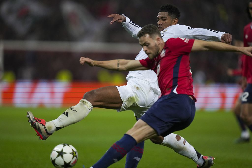 Pemain Real Madrid, Jude Bellingham (belakang), berebut bola dengan pemain Lille, Gabriel Gudmundsson, pada laga Liga Champions di Stade Pierre Mauroy, Villeneuve-d'Ascq, di luar kota Lille, Perancis, Rabu (2/10/2024). Lille menang dengan skor 1-0.