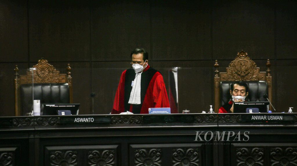 Hakim Konstitusi Aswanto (kiri) dan Hakim Anwar Usman di sela-sela sidang putusan uji materi UU ITE terkait pemblokiran internet, di Gedung Mahkamah Konstitusi, Jakarta, Oktober 2021. 