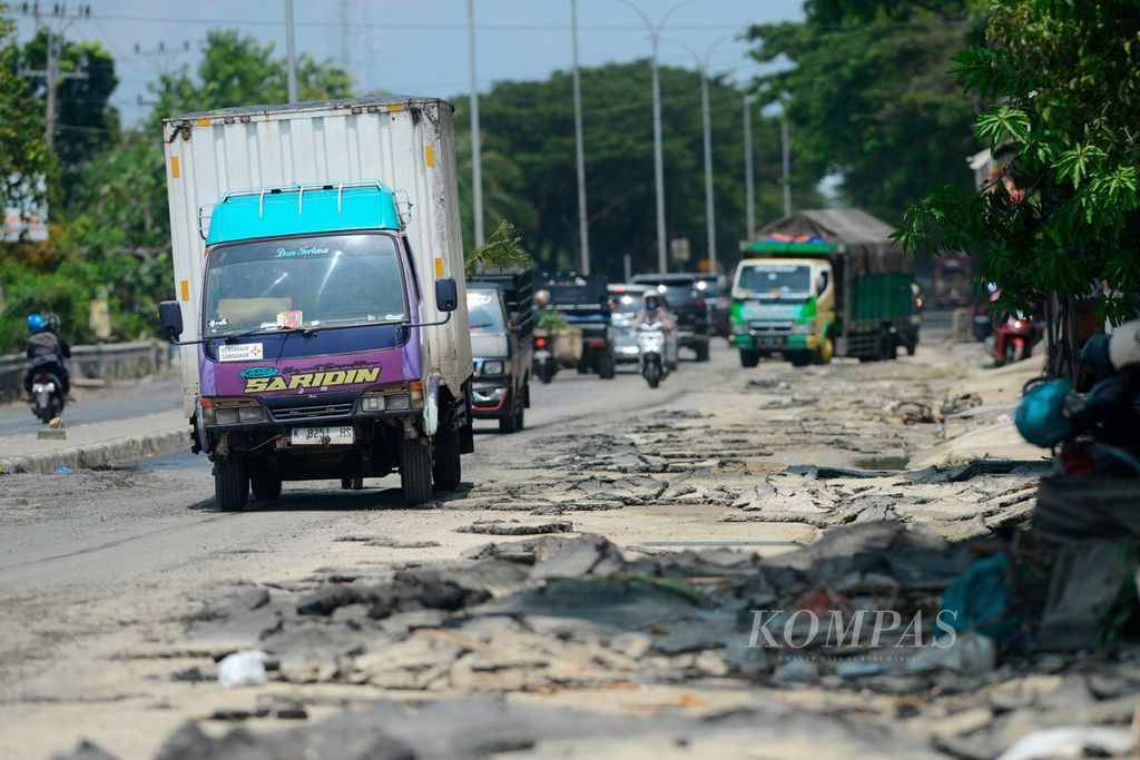 Truk melintasi jalur pantura Demak-Kudus dengan kondisi lapisan aspal yang mengelupas setelah terdampak banjir di Kecamatan Karanganyar, Kabupaten Demak, Jawa Tengah, Minggu (24/3/2024). 