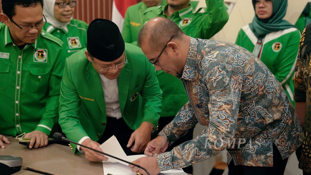 Ketua KPU Hasyim Asyari (kanan) memperhatikan SK Kementerian Hukum dan HAM yang diserahkan oleh Plt Ketua Umum Partai Persatuan Pembangunan (PPP) Mardiono di Kantor KPU, Jakarta, Senin (12/9/2022). 