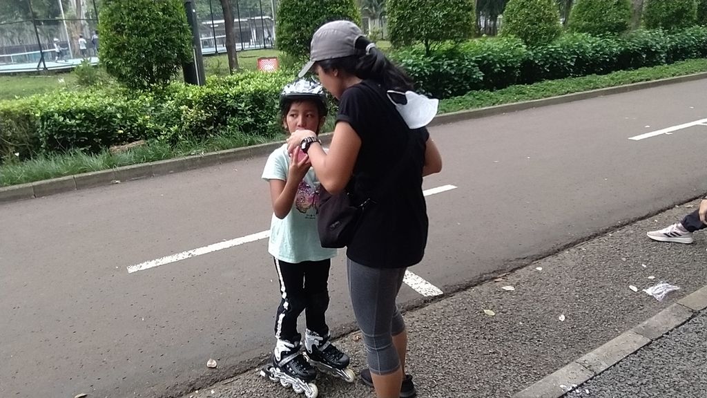 Salah satu orangtua tengah memberi minum kepada anaknya di sela latihan Garuda Muda Roller Skate Club di Jalan Gerbang B, Stadion Utama Gelora Bung Karno, Senayan, Jakarta, Sabtu (22/10/2022).