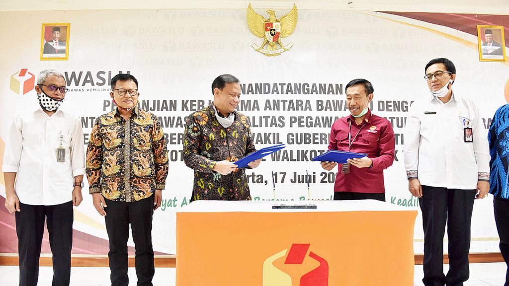Ketua Badan Pengawas Pemilu (Bawaslu) Abhan (ketiga dari kiri) bersama Ketua Komisi Aparatur Sipil Negara (KASN) Agus Pramusinto (kedua dari kanan) memegang dokumen Perjanjian Kerja Sama (PKS) Pengawasan Netralitas ASN pada Pilkada Serentak 2020 di Kantor Bawaslu, Jakarta, Rabu (17/6/2020). Kemitraan Bawaslu bersama KASN tersebut diharapkan bisa mewujudkan Pilkada Serentak 2020 yang langsung, umum, bebas, jujur, adil, dan beritegritas.