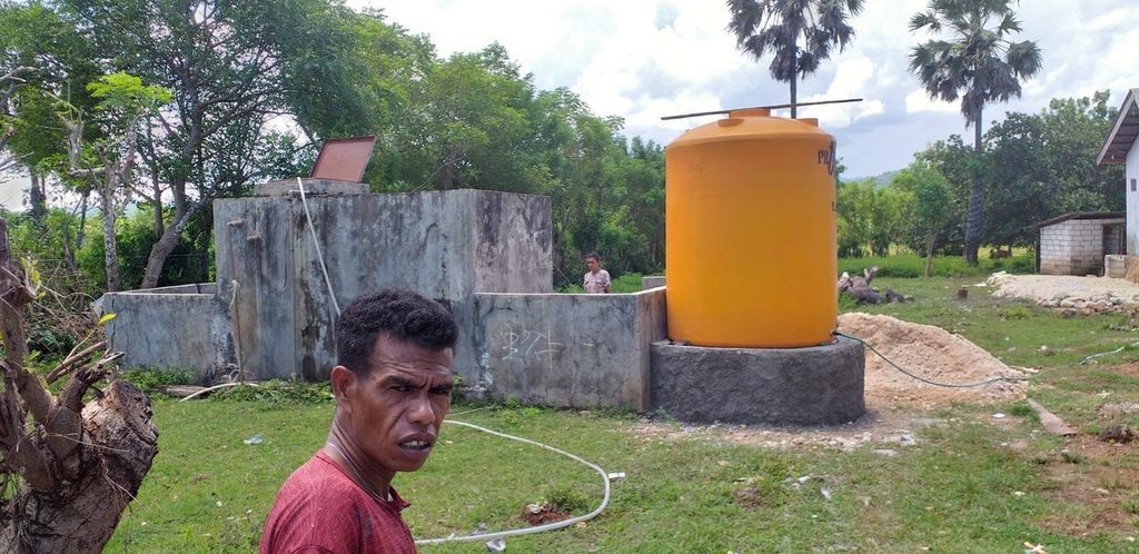 Melo Natun (42), warga Oelnasi, Kabupaten Kupang, NTT, Senin (20/2/2023), menarik pipa setelah mobil tangki mengisi air di bak tua yang dibangun Balai Sungai Wilayah 2 Nusa Tenggara, sekitar 2004 lalu. Sampai saat ini tujuh bak yang dibangun itu tidak terisi air Bendungan Tilong. Warga pun terpaksa membeli air tangki, mengadakan sumur bor, dan menadah air hujan untuk keperluan sehari-hari.