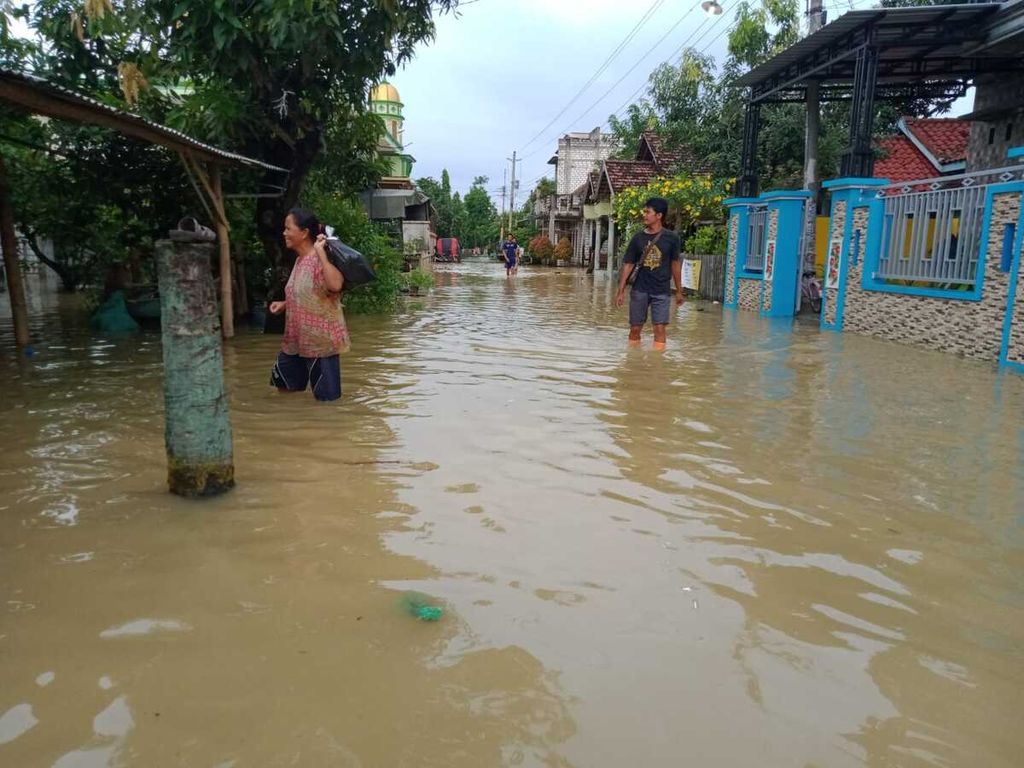 Warga beraktivitas di tengah genangan banjir di Desa Ketitang Wetan, Kecamatan Batangan, Kabupaten Pati, Jawa Tengah, Kamis (10/3/2022).