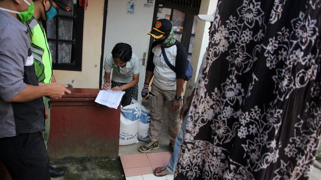 Warga menandatangani bukti penerimaan bantuan beras dari Bupati Bogor yang disalurkan petugas dari Kantor Desa Palasari, Kecamatan Cijeruk, Kabupaten Bogor, Jawa Barat, Selasa (5/5/2020). 