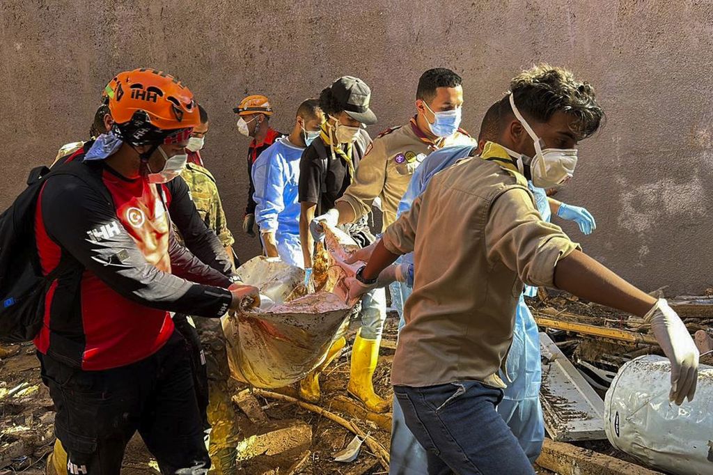 Dalam foto yang diberikan tim bantuan kemanusiaan dari Turki, IHH, petugas penyelamat membawa jenazah korban banjir di Derna, Libya, Rabu (13/9/2023). 