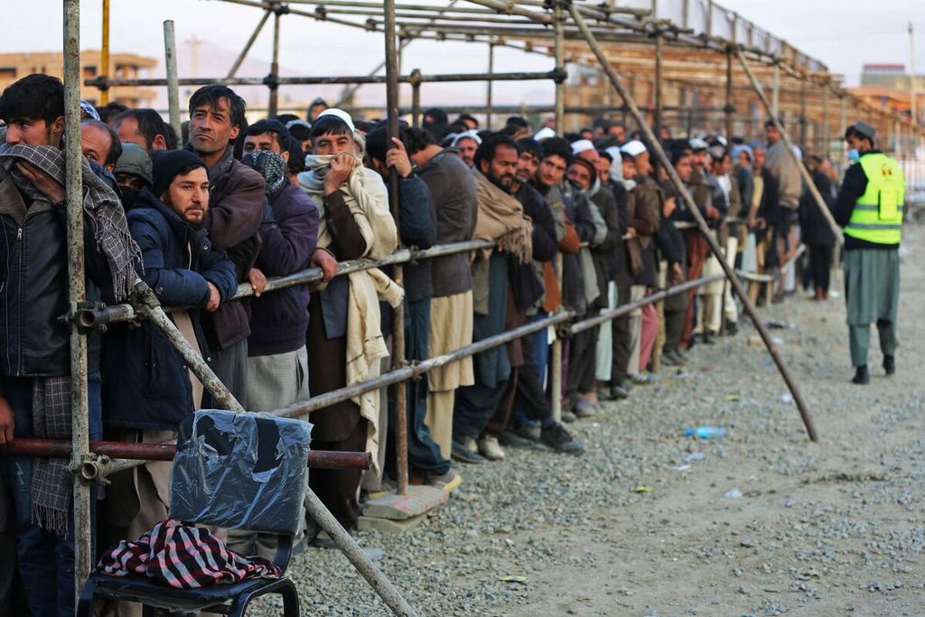 Kaum laki-laki di Afghanistan mengantre untuk menerima bantuan sosial dari lembaga swadaya masyarakat di Kabul, Afghanistan, Minggu (25/12/2022). Sejumlah LSM membekukan bantuan kepada Afghanistan karena Taliban melarang perempuan bekerja di bidang kemanusiaan.    
