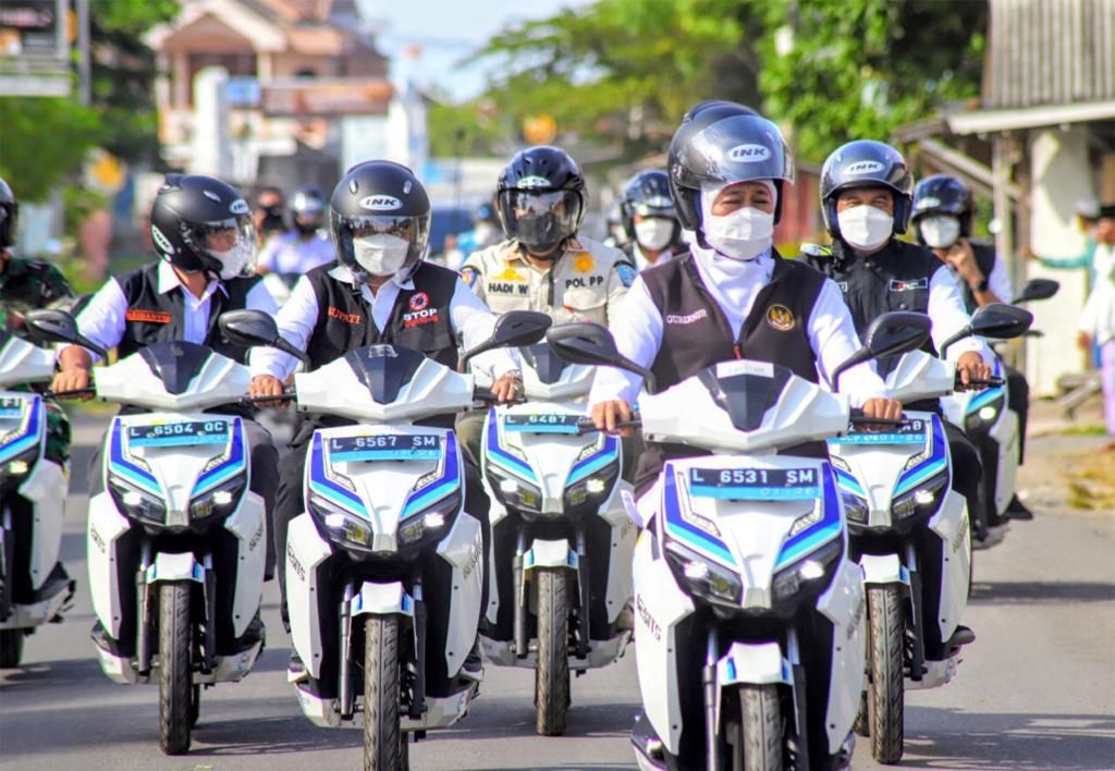 Gubernur Jatim Khofifah Indar Parawansa (depan) mengendarai motor listrik keliling Surabaya, Rabu (23/3/2022).
