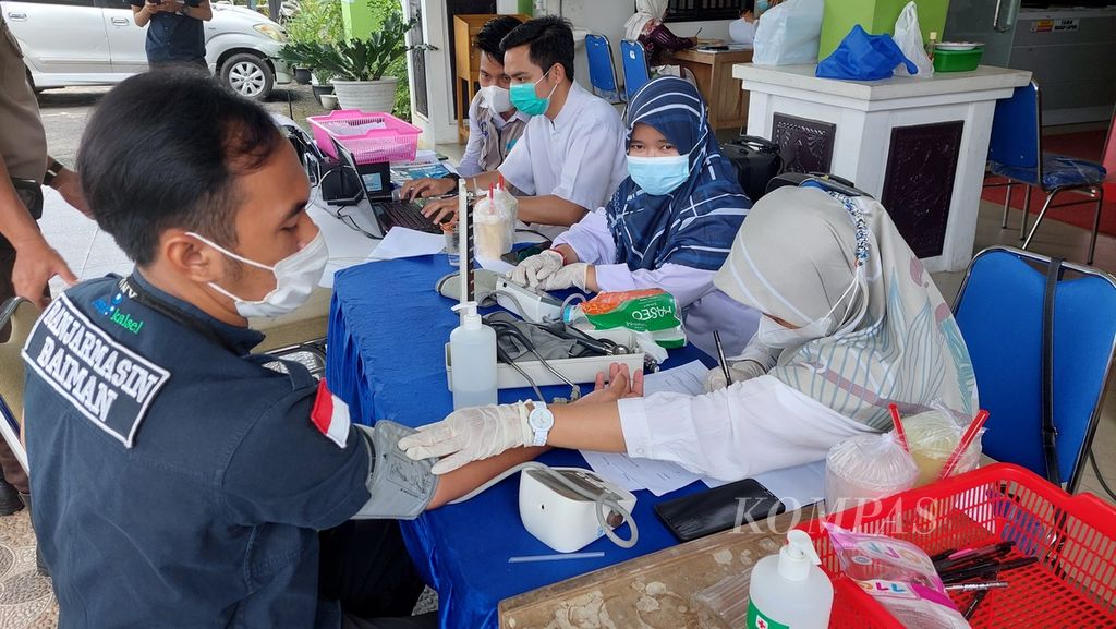 Petugas memeriksa tekanan darah sebelum memberikan vaksinasi Covid-19 dosis ketiga atau penguat (<i>booster</i>) kepada pegawai Pemkot Banjarmasin di Kantor Dinas Kesehatan Kota Banjarmasin, Kalimantan Selatan, Selasa (8/2/2022). Cakupan vaksinasi terus ditingkatkan dalam upaya menghadapi Covid-19 varian Omicron.