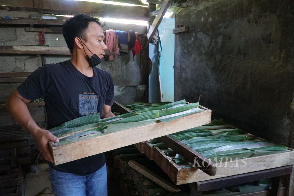 Pekerja meletakkan tempe seusai dicetak di pabrik tempe Darek Ani Cap Gunung Tiga, Kelurahan Alai Parak Kopi, Kota Padang, Sumatera Barat, Minggu (20/2/2022).