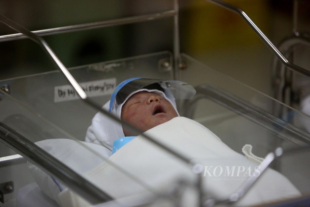 Bayi yang baru lahir terlelap di ruang bayi Rumah Sakit Ibu dan Anak Tambak, Jakarta, dengan menggunakan pelindung wajah (face shield), Senin (20/4/2020). 