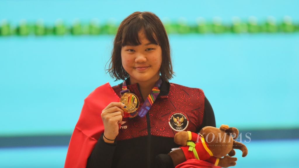 Flairene Candrea Wonomiharjo menunjukkan medali emas nomor 100 meter gaya punggung putri SEA Games Vietnam 2021 di Hanoi, Vietnam, Selasa (17/5/2022). 