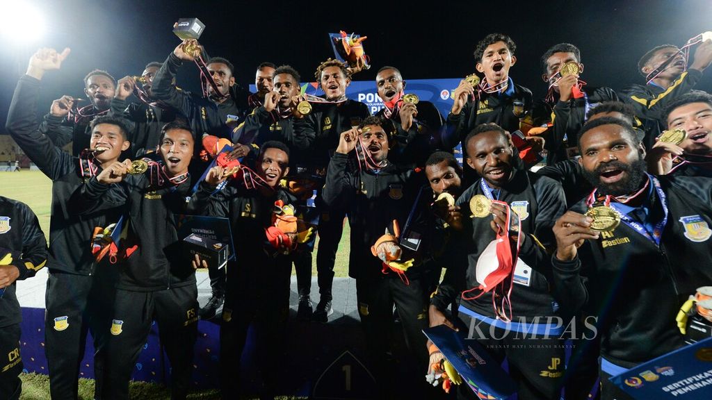 Para pemain tim sepak bola putra Papua memamerkan medali emas seusai menjuarai laga final sepak bola PON Papua 2021 menghadapi Aceh di Stadion Mandala, Kota Jayapura, Papua, Kamis (14/10/2021). 