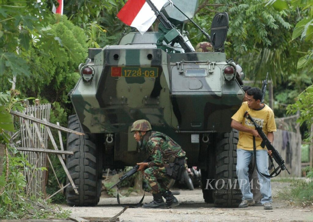 Dua anggota pasukan gabungan TNI dan Polri, Senin (25/8/2005), mengepung sejumlah anggota Gerakan Aceh Merdeka yang bersembunyi di rumah penduduk saat terjadi kontak senjata di Desa Lamphuk, Kecamatan Ulee Kareng, yang berjarak sekitar 4 kilometer dari Kota Banda Aceh. 