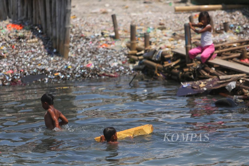  Anak-anak bermain di tengah air yang keruh karena limbah domestik di pantai perkampungan nelayan Muara Angke, Jakarta Utara, Sabtu (15/8/2020). Pantai dengan air kotor yang menjadi tempat bermain ini dapat membahayakan kesehatan mereka. Belakangan ini, merebak kasus gagal ginjal akut pada anak yang berakibat fatal.