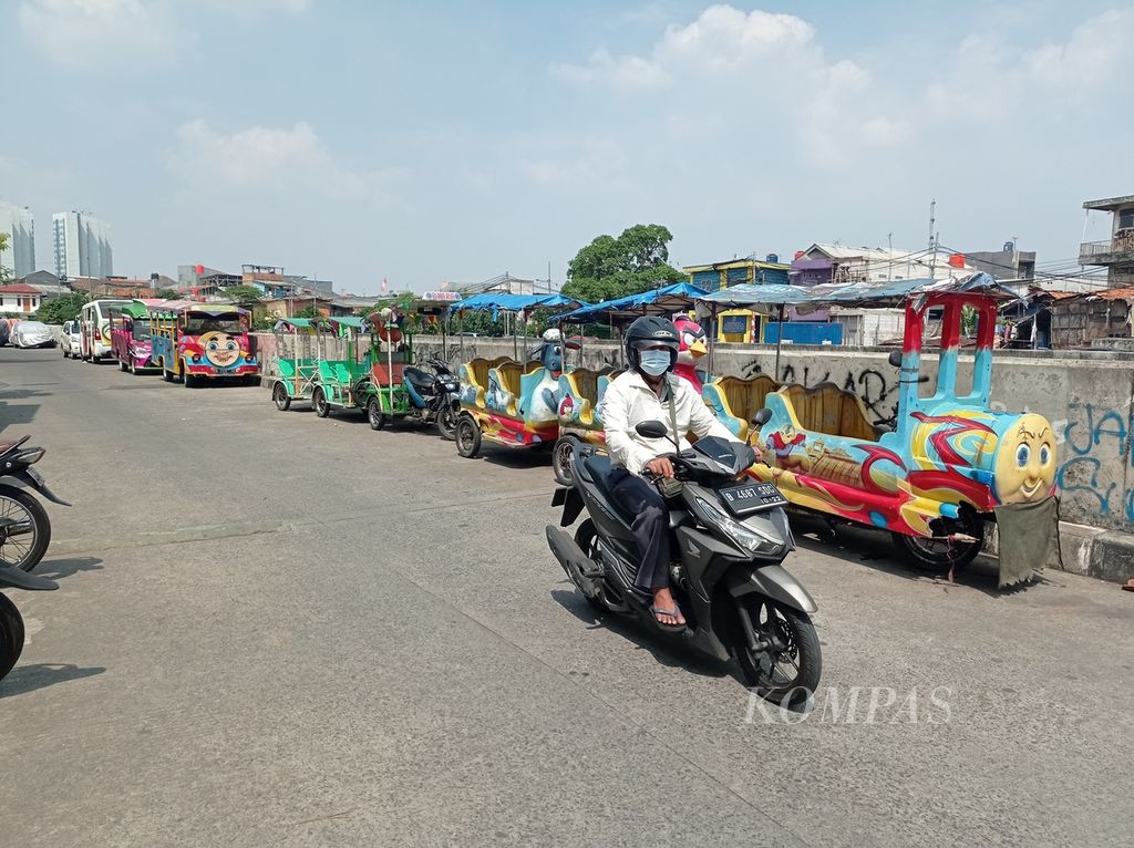 Deretan odong-odong terparkir di Jalan Inspeksi Kali Ciliwung, Kampung Pulo, Kecamatan Jatinegara, Jakarta Timur, Minggu (31/7/2022).