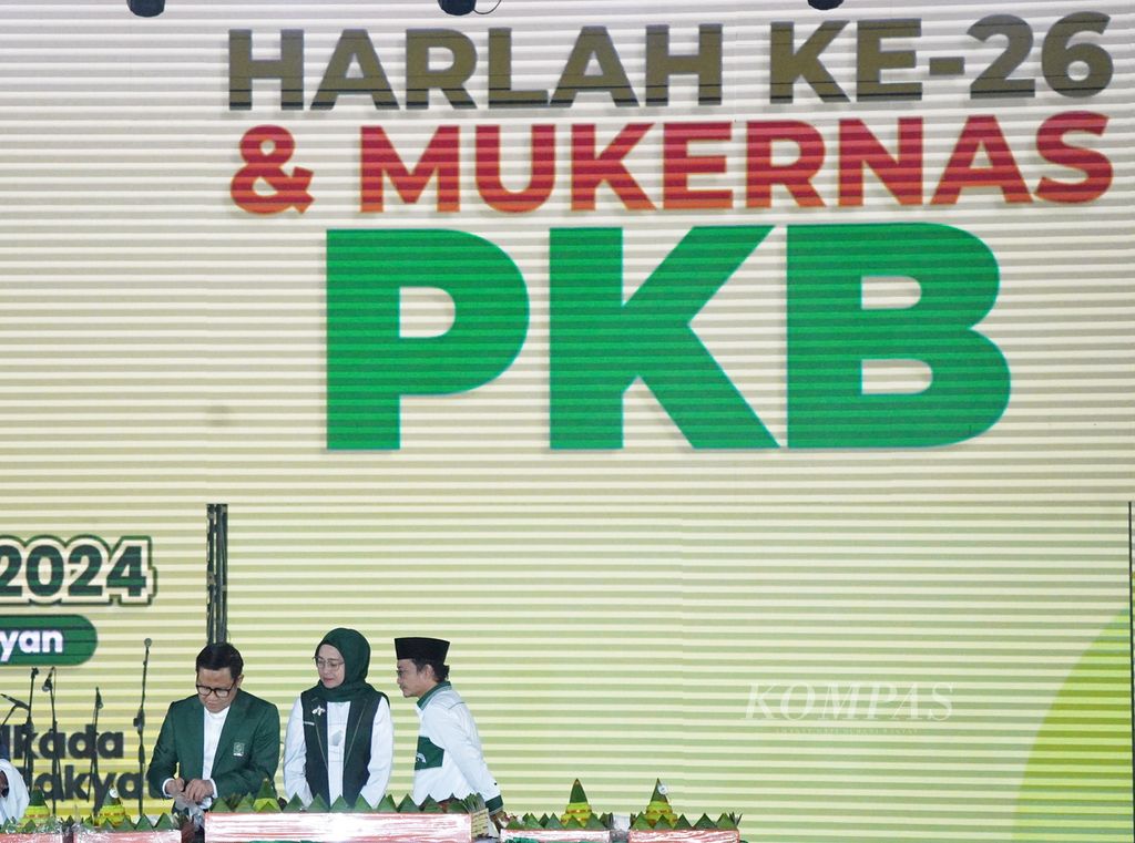 Ketua Umum PKB Muhaimin Iskandar memotong tumpeng didampingi istrinya, Rustini Muhaimin, dan Sekretaris Jenderal PKB Hasanuddin Wahid dalam puncak Harlah Ke-26 PKB di JCC, Jakarta, Selasa (23/7/2024). 