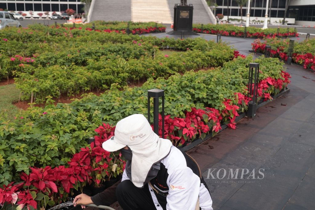 Petugas pertamanan menyirami bunga di taman depan Gedung Nusantara atau "gedung kura-kura", Kompleks Parlemen, Jakarta, Senin (14/8/2023). 