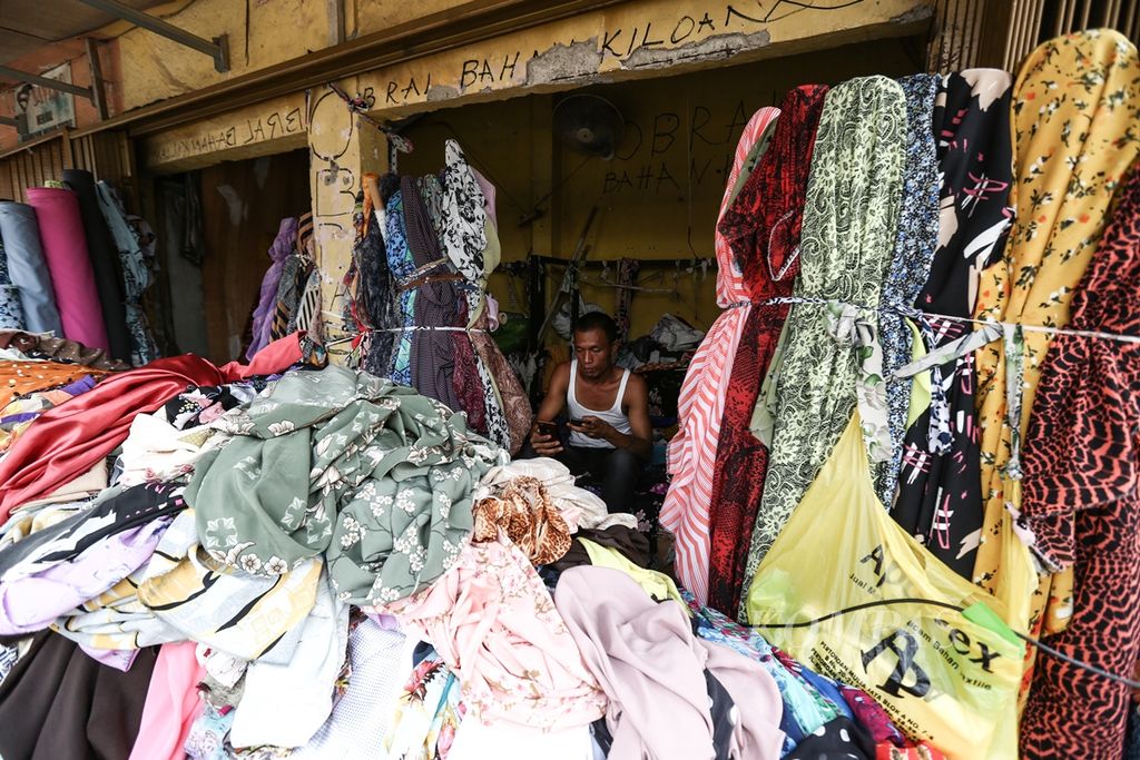 Pedagang kain menunggu pembeli di kios kain di kawasan Cipadu, Kota Tangerang, Banten, September 2019.