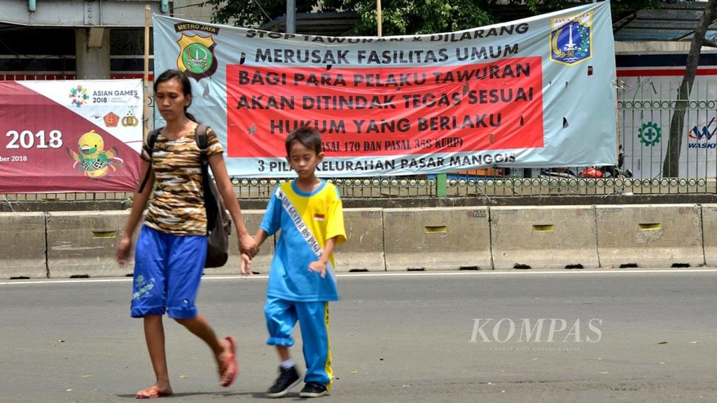 Spanduk yang mengajak untuk menghentikan tawuran di pagar pembatas jalan di Jalan Sultan Agung di sekitar halte bus Transjakarta Pasar Rumput, Jakarta Selatan, Kamis (6/9/2018). 