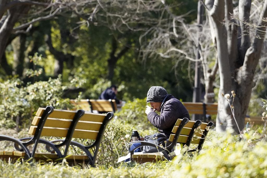 Seseorang warga sedang menyesap minuman saat makan siang di sebuah taman di Tokyo, Jepang, pada 6 Februari 2023. 