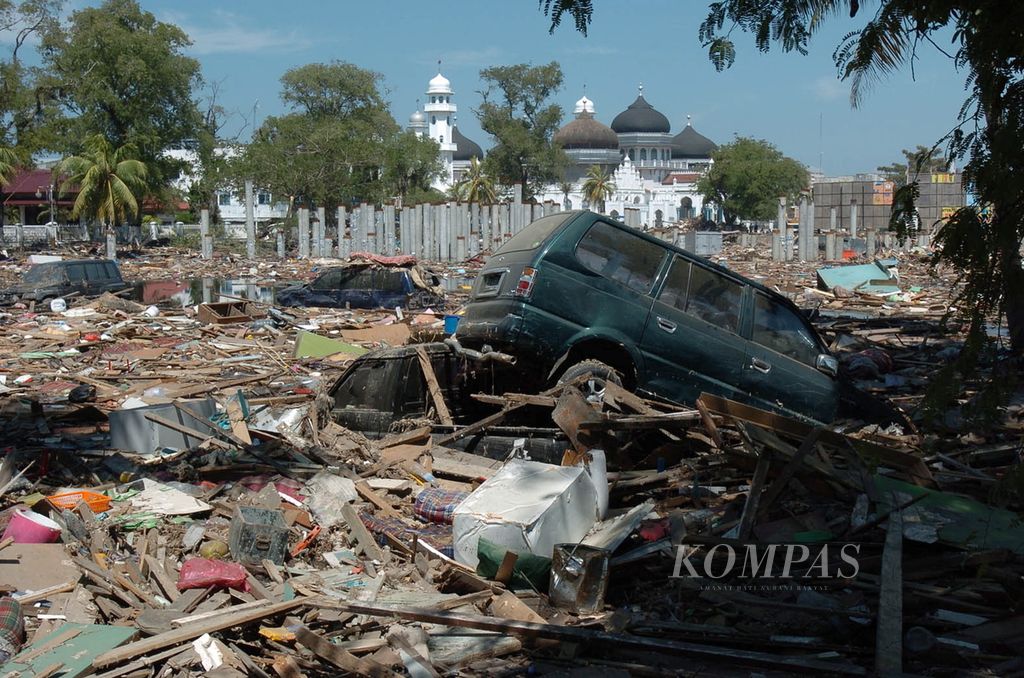 Sebuah mobil Kijang yang terpelanting akibat gempa dan gelombang tsunami berada di antara puing-puing bangunan di Ujung Rimba, Banda Aceh, Kamis (30/12/2004). 