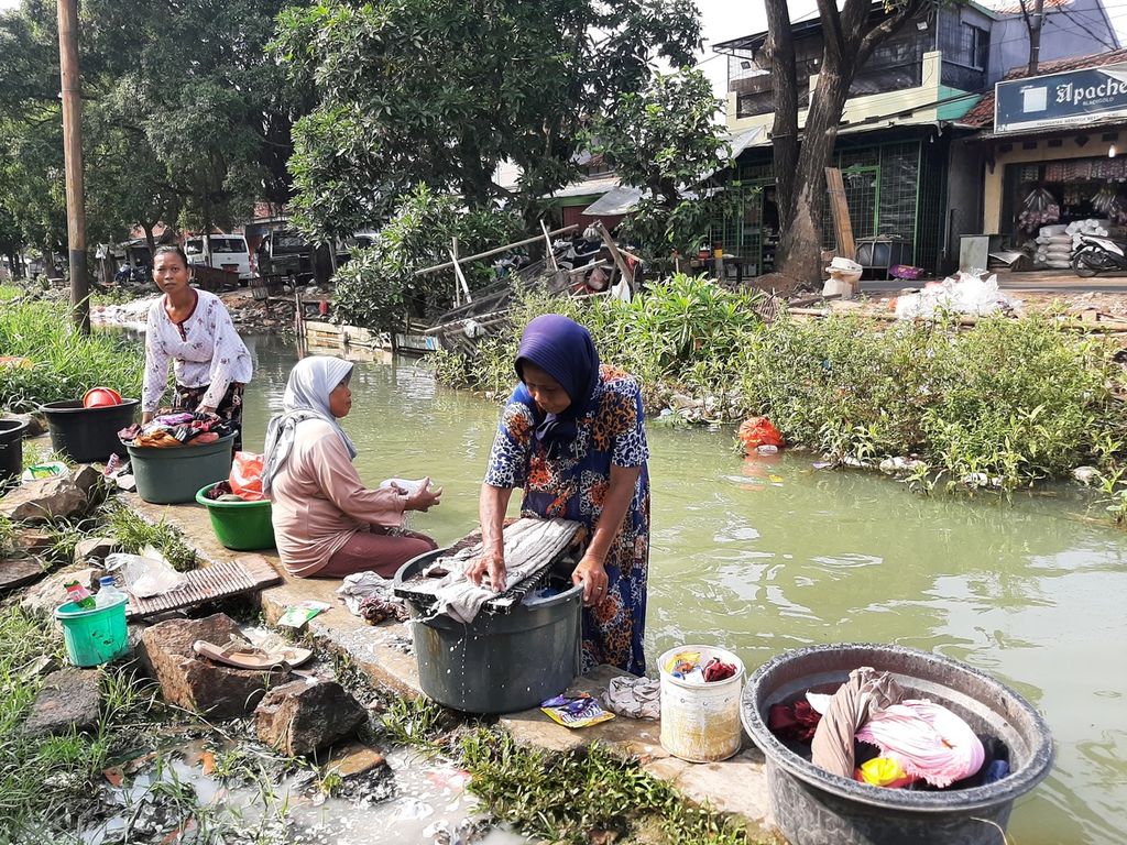 Warga menggunakan aliran kali yang terkontaminasi sampah di Desa Bojong Renged, Kecamatan Teluknaga, Kabupaten Tangerang, Banten, Senin (17/10/2022).