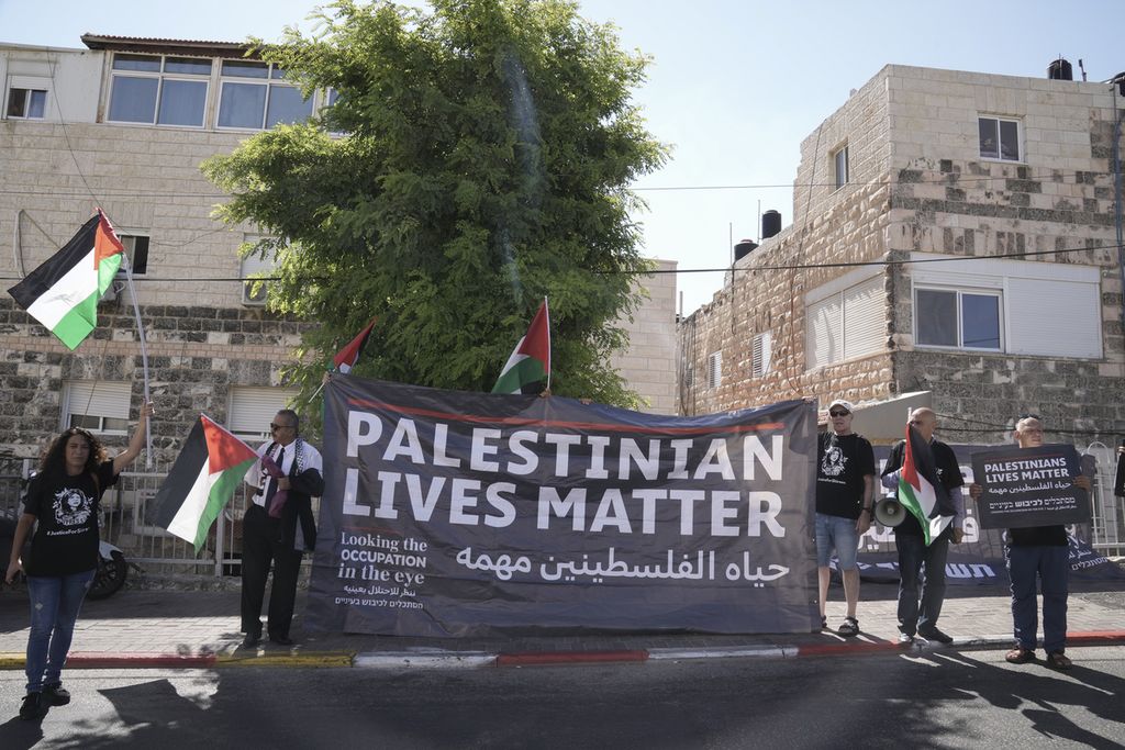 Sejumlah demonstran membawa spanduk yang berisikan pesan "Hidup dan Kehidupan Rakyat Palestina Penting" saat berdemo di dekat RS Augusta VIctoria di Jerusalem Timur, Jumat (15/7/2022).