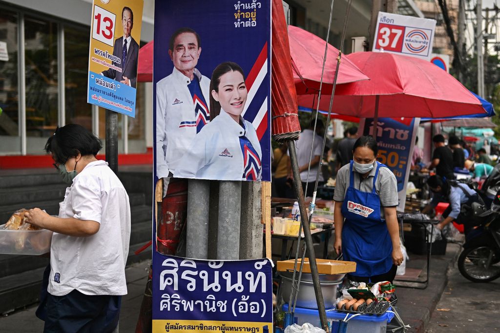 Para penjual di jalanan menunggu pelanggan di sela-sela plakat kampanye di sepanjang jalan di Bangkok, Thailand, pada 10 Mei 2023, menjelang pemilihan umum Thailand 14 Mei.