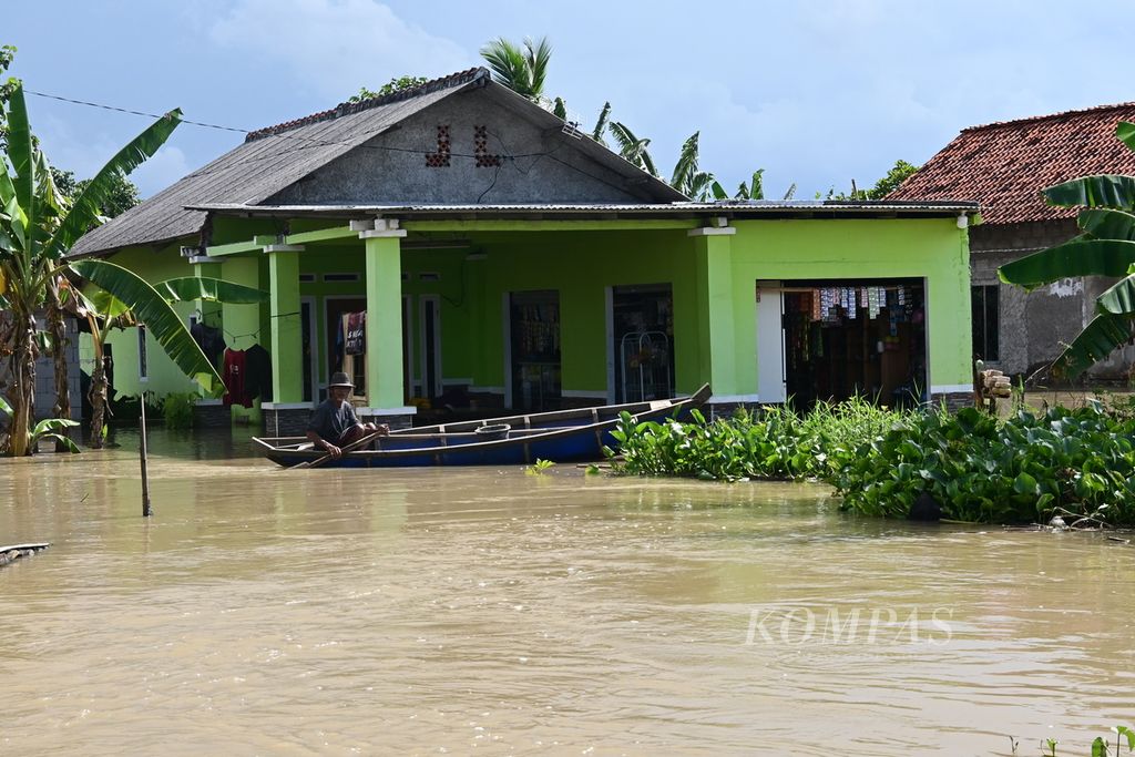 Warga di Desa Pantai Harapan Jaya, Muara Gembong, Kabupaten Bekasi, Jawa Barat, menggunakan perahu untuk beraktivitas akibat jalanan lumpuh tergenang banjir. Banjir yang terjadi sejak 24 Februari itu belum surut hingga Jumat (3/3/2023) siang.