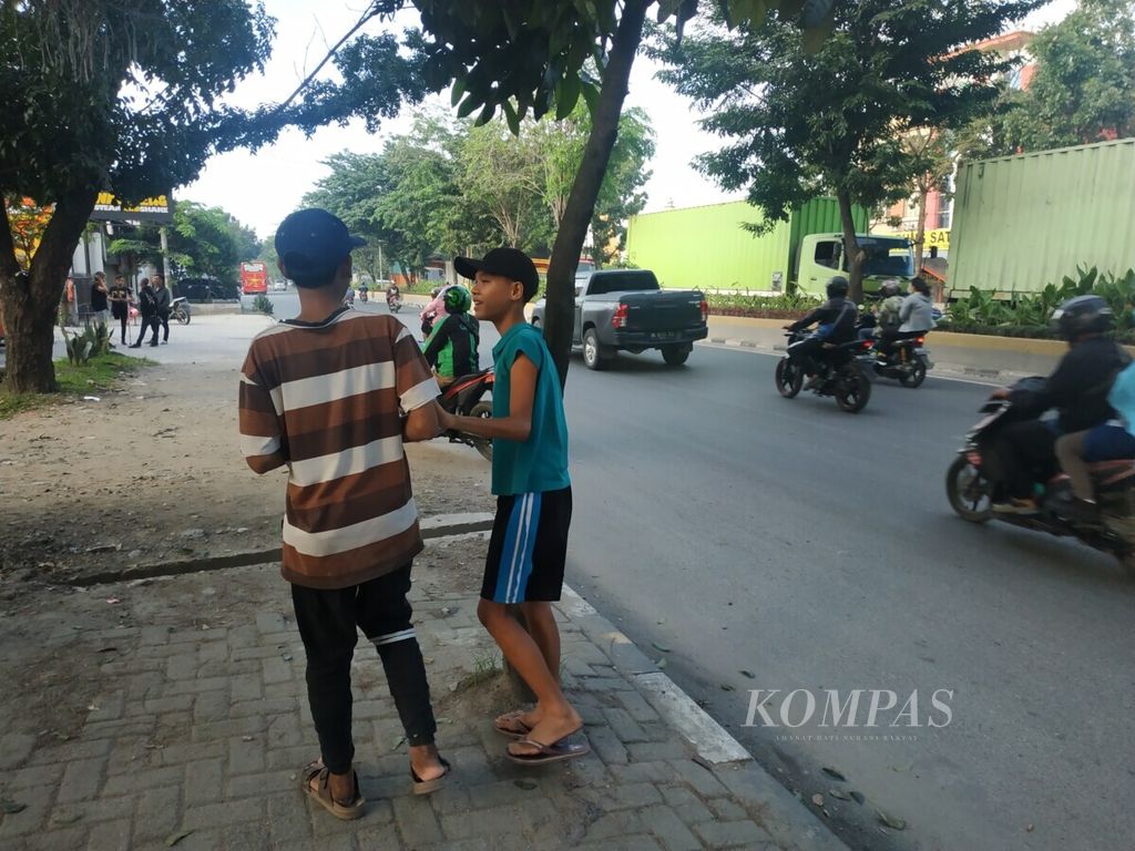 Anak-anak berjualan di Simpang Pondok Kelapa, Medan, Sumatera Utara, setelah mereka pulang sekolah, Jumat (2/11/2019). Banyak anak yang turun ke jalan untuk membantu ekonomi keluarganya.