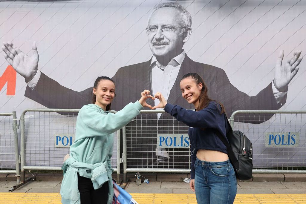 Pendukung kubu oposisi Turkir di depan foto tokoh oposisi Turki Kemal Kilicdaroglu di sela kampanye pada 12 Mei 2023. Dalam pemilu presiden pada 14 Mei 2023, Kilicdaroglu menempati urutan kedua. Calon petahana, Presiden Recep Tayyip Erdogan unggul dan meraih 49,4 persen suara sah. 