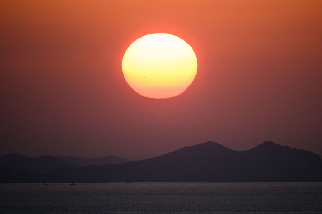 Matahari terlihat terbit di atas daratan Korea Utara dilihat dari titik pengamatan di Pulau Baekryeong yang terletak dua kilometer dari perbatasan maritim de facto dan hanya 14 kilometer dari daratan Korea Utara, Jumat (28/10/2022). 