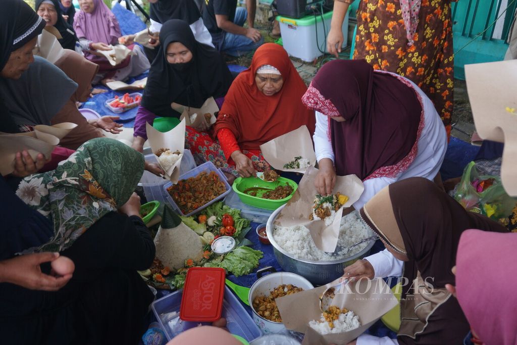 Warga makan bersama dalam perayaan Tahun Baru Islam 1444 H di Sokaraja Kulon, Sokaraja, Banyumas, Jawa Tengah, Sabtu (30/7/2022).