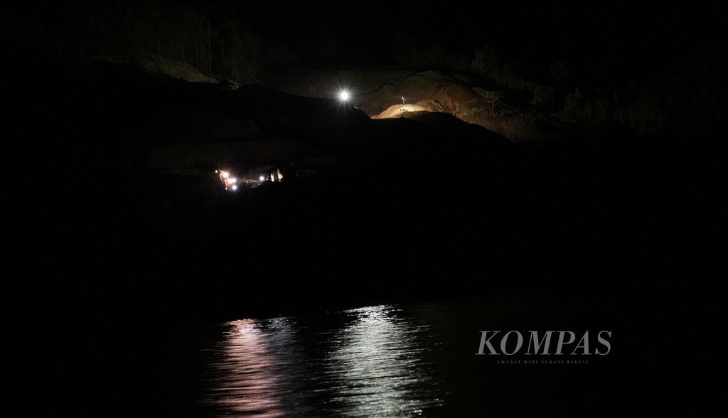 Cahaya lampu menandakan kegiatan penambangan di salah satu bukit di Teluk Buli, Kecamatan Maba, Kabupaten Halmahera Timur, Maluku Utara. Nelayan bagan mengeluhkan kegiatan penambangan malam hari dan menggunakan lampu akan mengurangi ikan yang mendekat ke bagan mereka. 