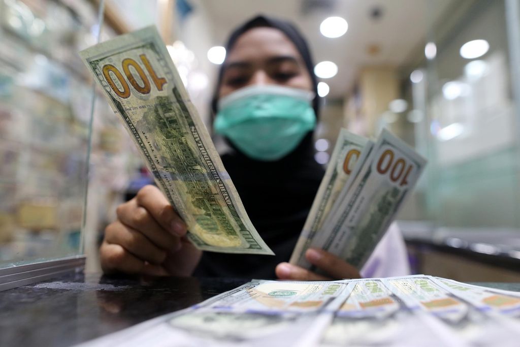 Karyawan menghitung dollar AS di tempat penukaran valuta asing PT Valuta Artha Mas, ITC Kuningan, Jakarta, Jumat (16/10/2020).