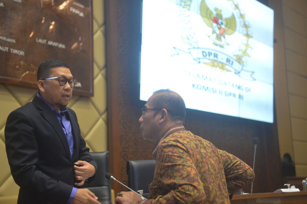 Ketua Komisi II Ahmad Doli Kurnia (kiri) berbincang dengan Ketua Komisi Pemilihan Umum (KPU) Hasyim Asyari (kanan) selepas pembahasan rancangan peraturan KPU bersama Komisi II DPR di Kompleks Parlemen, Senayan, Jakarta, Senin (3/10/2022). 