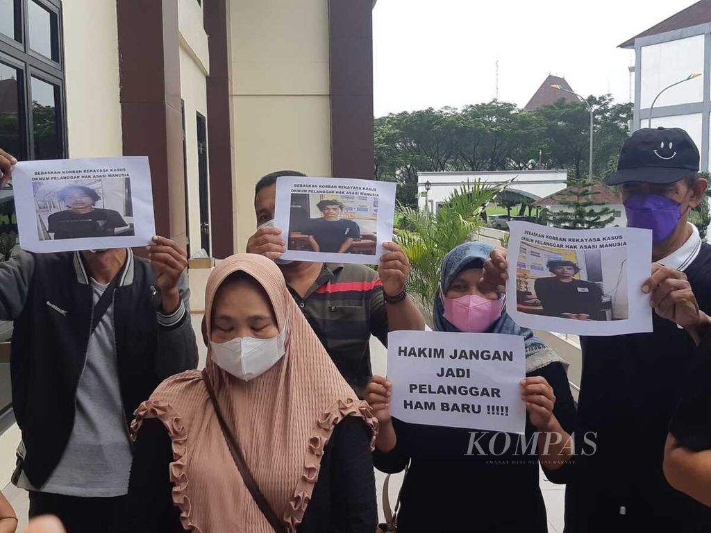 Keluarga dari empat terdakwa begal di Bekasi membentangkan sejumlah spanduk berisi tuntutan di Pengadilan Negeri Cikarang, Bekasi, Jaw Barat, Kamis (21/4/2022) siang. Mereka kecewa dengan majelis hakim yang menunda sidang putusan.