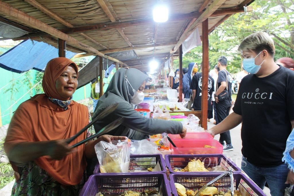Pedagang gorengan di Pasar Wadai, Kota Palangkaraya, Kalimantan Tengah, melayani pembeli, Selasa (5/4/2022).