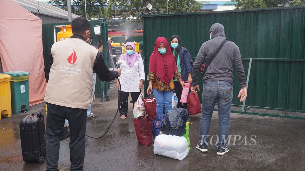 Penyemprotan disinfektan terhadap pasien Covid-19 yang akan pulang setelah perawatan di Rumah Sakit Lapangan Komando Gabungan Wilayah Pertahanan II, Surabaya, Jawa Timur, Sabtu (19/6/2021). 