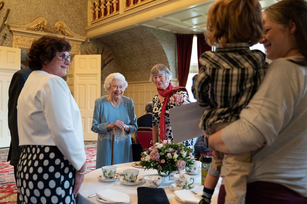 Ratu Inggris Elizabeth II (kiri tengah) berbincang-bincang dengan wakil dari sebuah kelompok komunitas setempat dalam perayaan dimulainya Peringatan Platinum (masa kekuasaannya ke-70 tahun) di Sandringham House, kediamannya di Norfolk, Inggris.