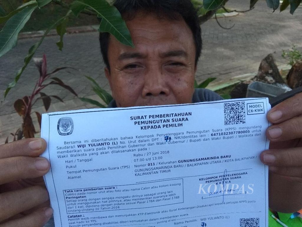 Agus Suprayitno, Ketua RT 30 Cluster Berau Wika, Balikpapan, menunjukkan surat pemberitahuan pemungutan suara kepada pemilih, atau biasa dikenal sebagai formulir C6-KWK, Minggu (24/6/2018) sore,